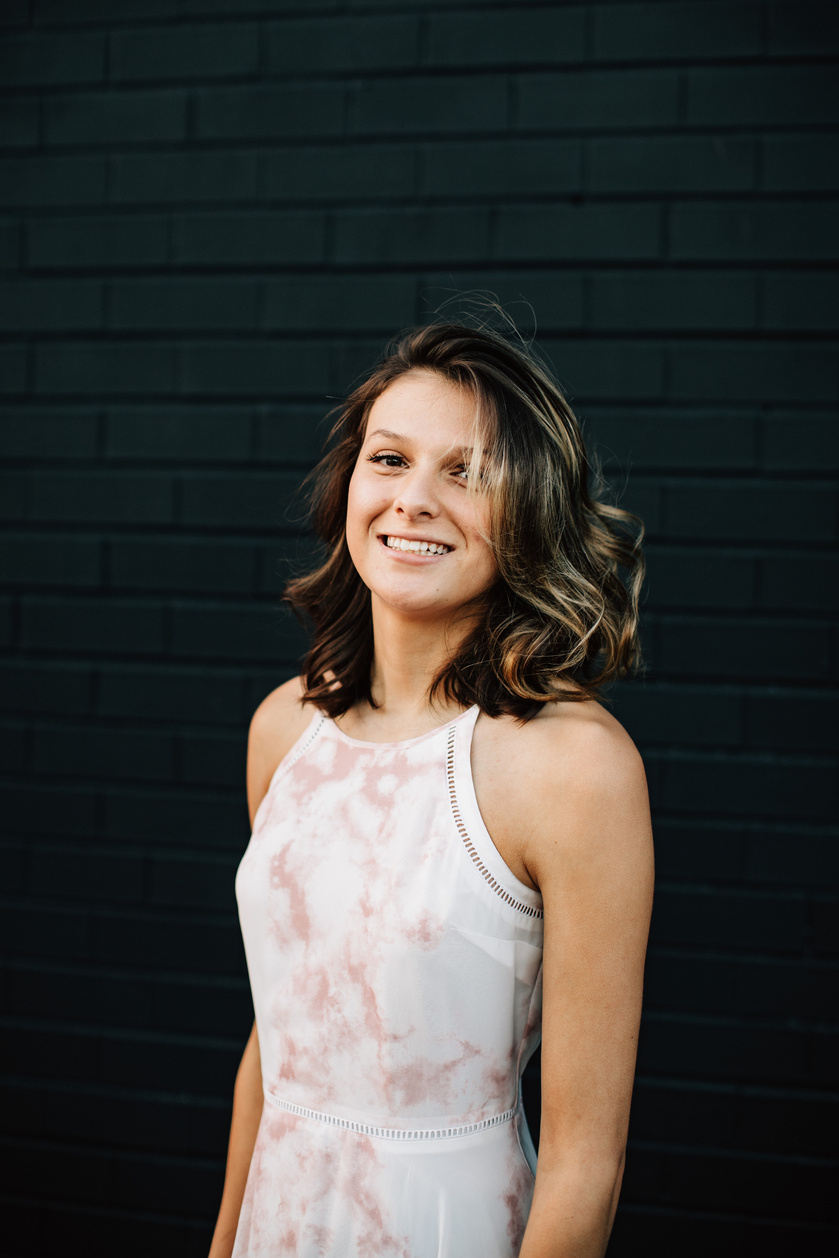 Portrait of Smiling Woman against Black Brick Wall